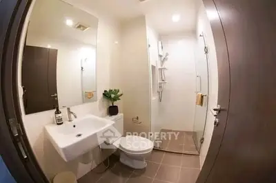 Modern bathroom with glass shower and sleek fixtures in a contemporary apartment.