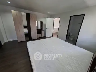 Spacious bedroom with modern wardrobe and ensuite bathroom in a stylish apartment.