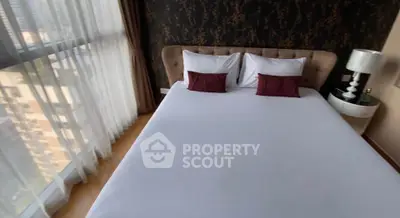 Luxurious bedroom with large window and elegant decor in high-rise apartment