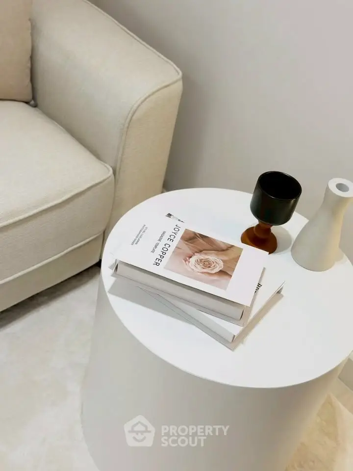 Stylish modern living room corner with elegant round table and cozy beige sofa.