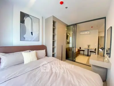 Modern bedroom with stylish decor and sliding glass doors leading to a cozy living area.