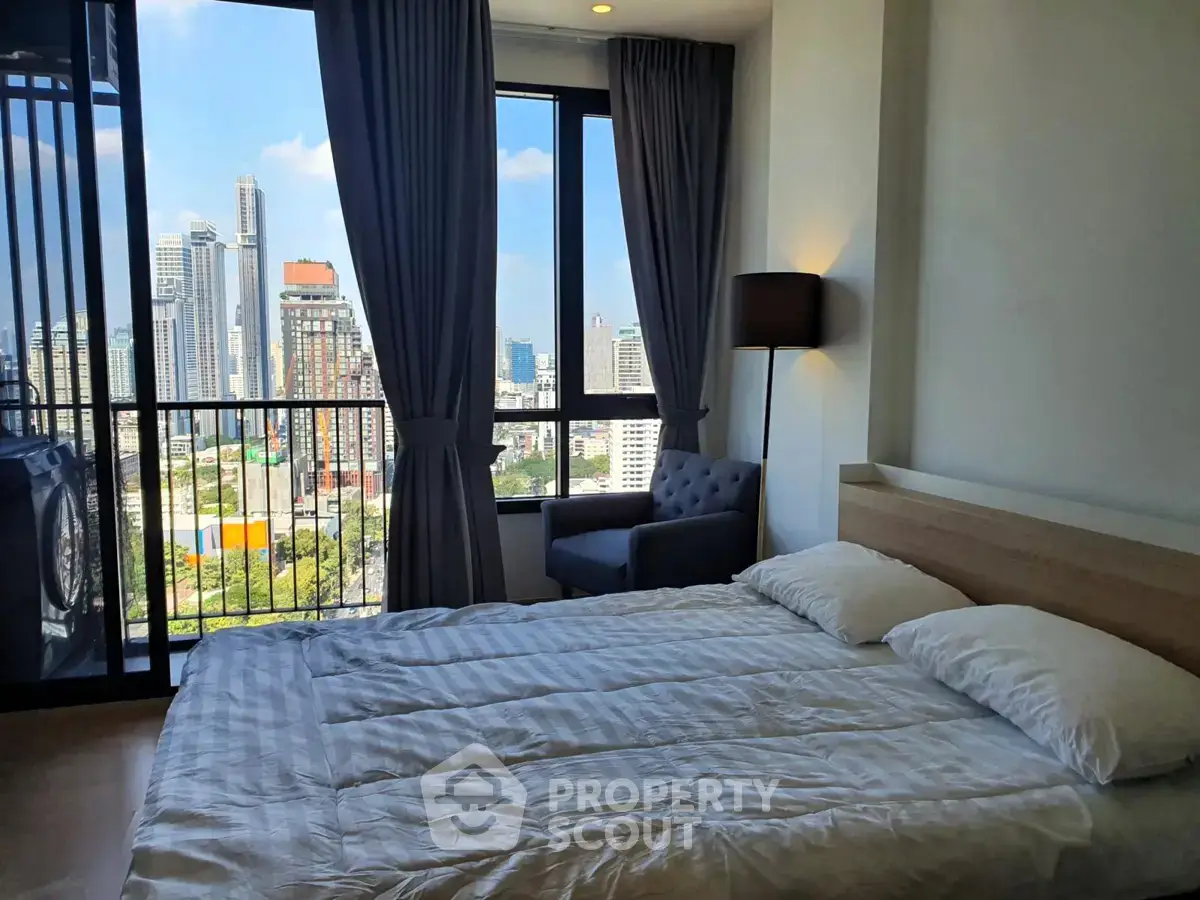 Modern bedroom with city view and large windows in high-rise apartment