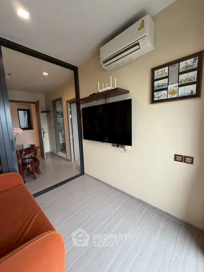 Modern living room with air conditioning and wall-mounted TV in a stylish apartment.