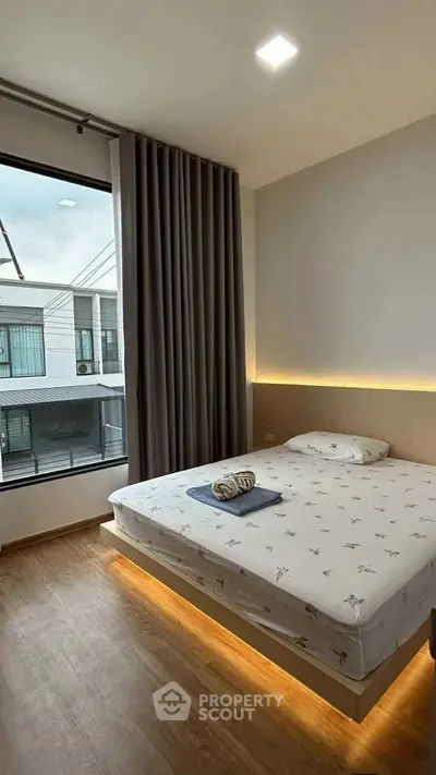 Modern bedroom with large window and stylish lighting in a contemporary home.