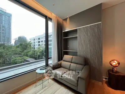 Modern living room with large window and cozy seating area overlooking cityscape.