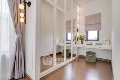Elegant bedroom with mirrored wardrobe and stylish vanity area