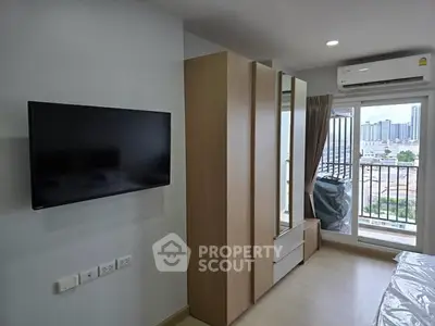 Modern bedroom with balcony view, featuring sleek wardrobe and wall-mounted TV in a stylish apartment.