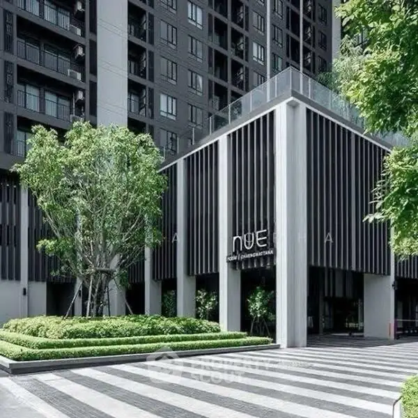 Modern building entrance with sleek design and lush greenery