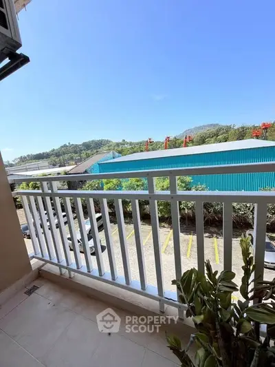 Spacious balcony with scenic view of lush greenery and industrial area