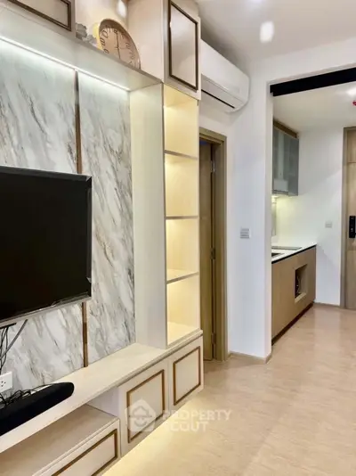 Modern living room with sleek TV unit and open kitchen layout