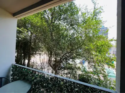 Charming balcony with lush greenery and city view, perfect for relaxation and outdoor dining.