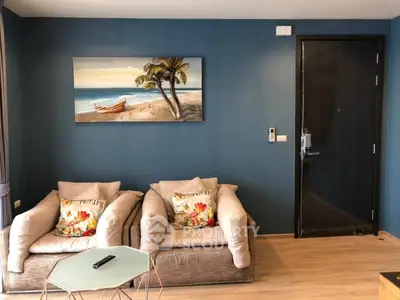 Stylish living room with beach-themed decor and cozy seating in modern apartment.