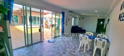 Spacious interior with sliding glass doors leading to a sunny patio, featuring modern tiled flooring.