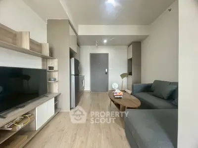 Modern living room with sleek furniture and open kitchen layout in a stylish apartment.