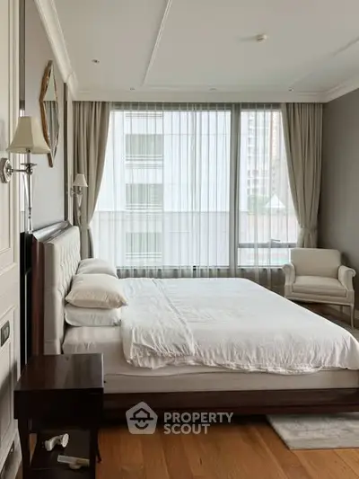 Luxurious bedroom with large windows and elegant furnishings in a modern apartment.