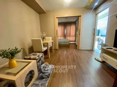 Modern open-plan living room with wooden flooring and cozy bedroom view.