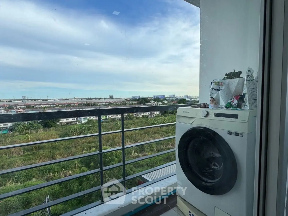 Scenic balcony view with modern washing machine in high-rise apartment.