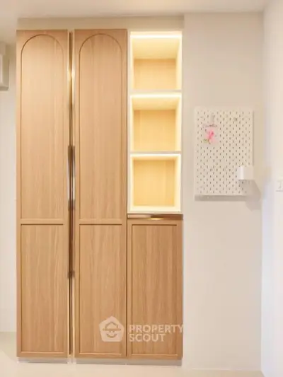 Modern wooden storage cabinet with built-in lighting in a stylish interior space.