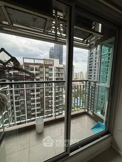 High-rise apartment balcony with city view and modern buildings.