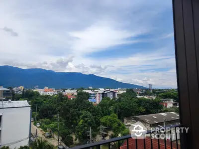 Stunning mountain view from a high-rise balcony in a vibrant urban setting.