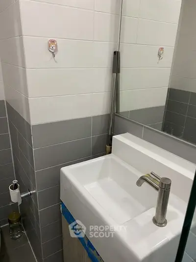 Modern bathroom with sleek sink and stylish tile design, perfect for contemporary living.