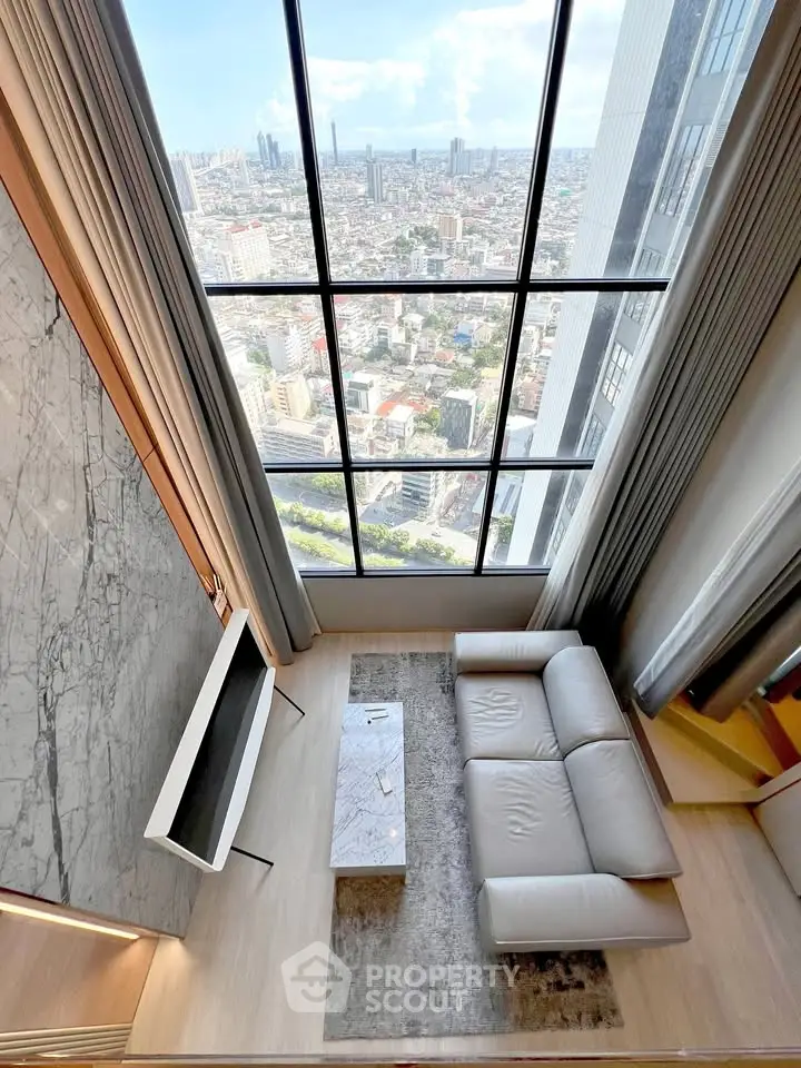 Luxurious high-rise living room with stunning city view through floor-to-ceiling windows.