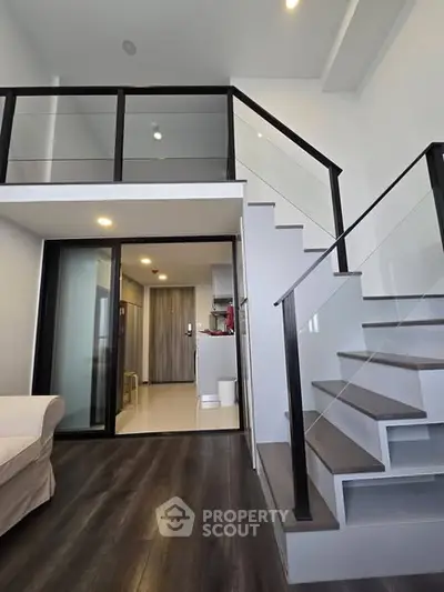 Modern duplex apartment with sleek staircase and open kitchen layout, perfect for urban living.