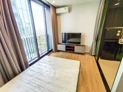 Modern bedroom with balcony and city view, featuring sleek design and natural light.
