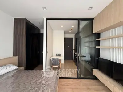 Modern studio apartment with sleek design, featuring a cozy bedroom and open living area with stylish furniture.