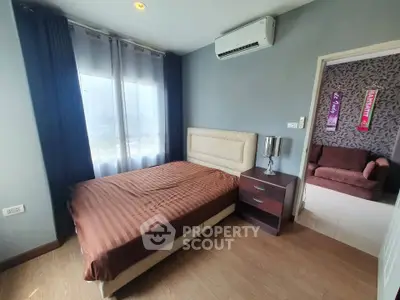 Cozy bedroom with modern decor and natural light, featuring an air conditioner and stylish furniture.