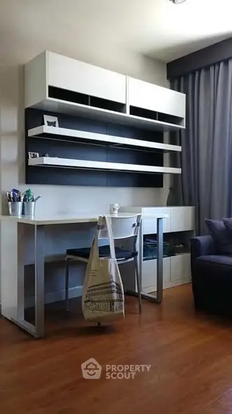 Modern study room with sleek desk, shelving, and comfortable seating for an ideal work-from-home setup.