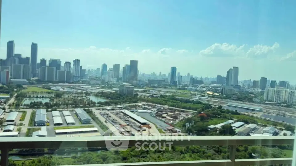 Stunning cityscape view from high-rise balcony overlooking urban skyline and lush greenery.