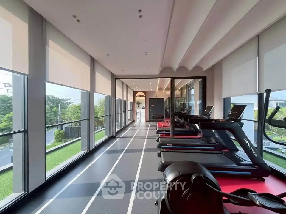 Modern gym with treadmills and large windows offering scenic views, perfect for fitness enthusiasts.