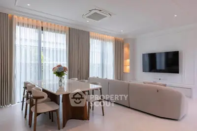 Elegant living room with modern furniture and large windows, perfect for family gatherings.