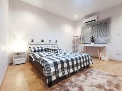 Cozy bedroom with stylish decor and natural light, featuring a comfortable bed and modern furnishings.