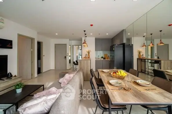 Modern open-plan living room and kitchen with stylish decor and dining area.