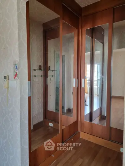 Spacious bedroom with elegant wooden wardrobe and mirrored doors