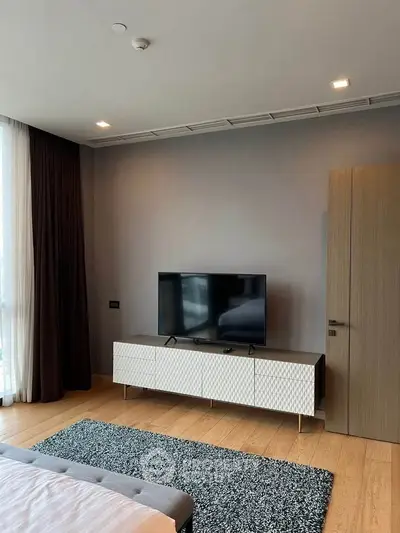 Modern bedroom with stylish TV console and cozy ambiance