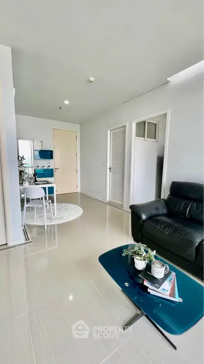 Modern living room with sleek furniture and open layout, featuring a cozy seating area and stylish decor.