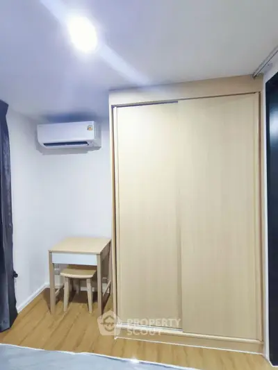 Cozy bedroom with modern air conditioning and compact wooden furniture