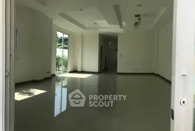 Spacious unfurnished living room with large windows and glossy tile flooring.