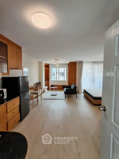 Spacious open-plan living room with modern furnishings and natural light, perfect for comfortable living.
