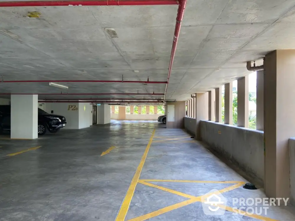 Spacious underground parking area with ample lighting and marked spaces.