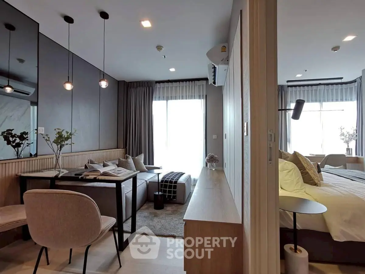 Modern open-plan living room and bedroom with stylish decor and natural light.