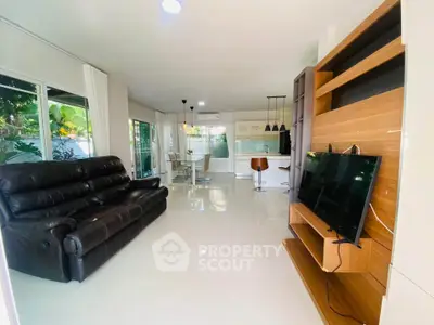 Spacious modern living room with sleek furniture and open kitchen layout, perfect for entertaining.