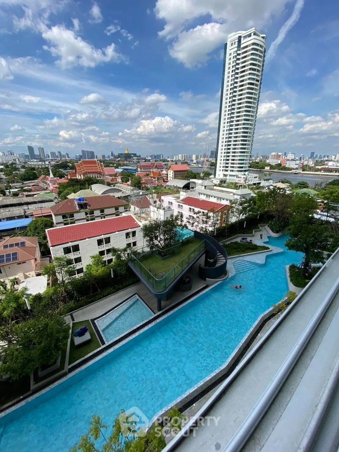Stunning aerial view of luxurious residential pool with cityscape backdrop, perfect for urban living enthusiasts.