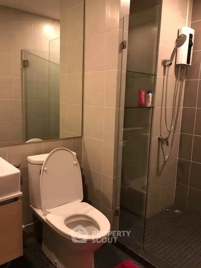 Modern bathroom with glass shower and sleek fixtures in contemporary apartment.