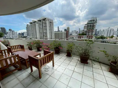 Spacious balcony with city skyline view and outdoor seating, perfect for relaxation.