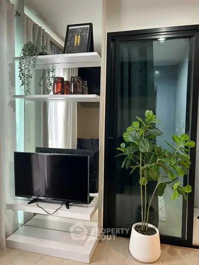 Modern living room with sleek TV stand and indoor plant, perfect for stylish urban living.