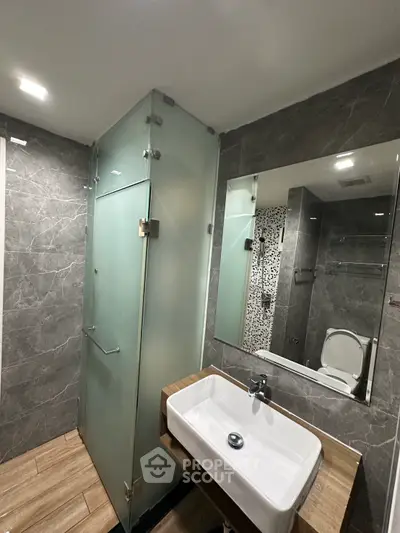 Modern bathroom with glass shower and stylish sink in luxury apartment